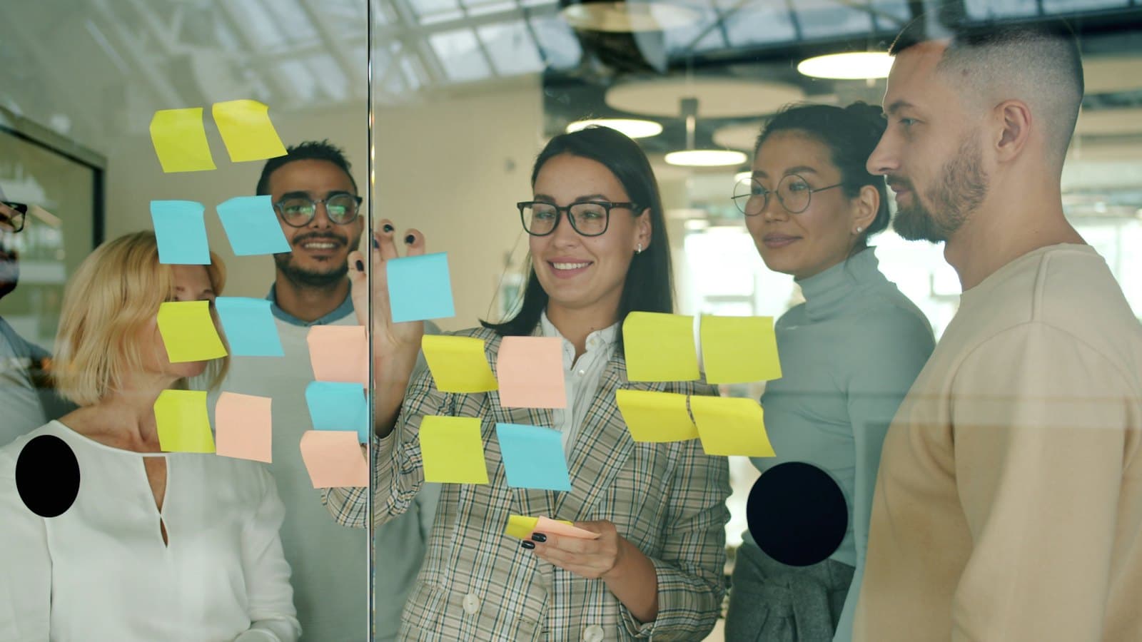 A team planning features with sticky notes on a glass wall